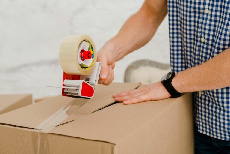 Man taping a box closed
